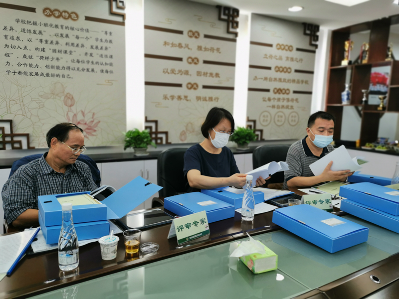 专家评委在广州市越秀区雅荷塘小学翻阅评审佐证材料.jpg